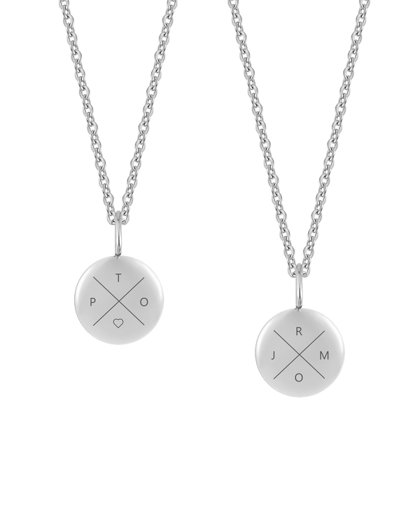 AYA X halsband från byRavn i silverfärgat rostfritt stål, två små hängen med bokstäverna "T P O ♡" och "R J M O" graverade i kors
