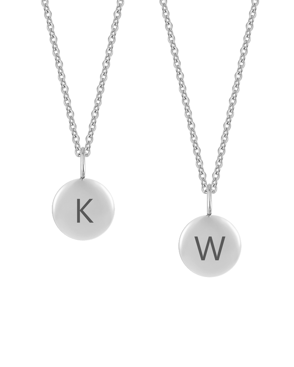 AYA LETTER halsband från byRavn i silverfärgat rostfritt stål, två små runda hängen med de stora bokstäverna "K" och "W" graverade