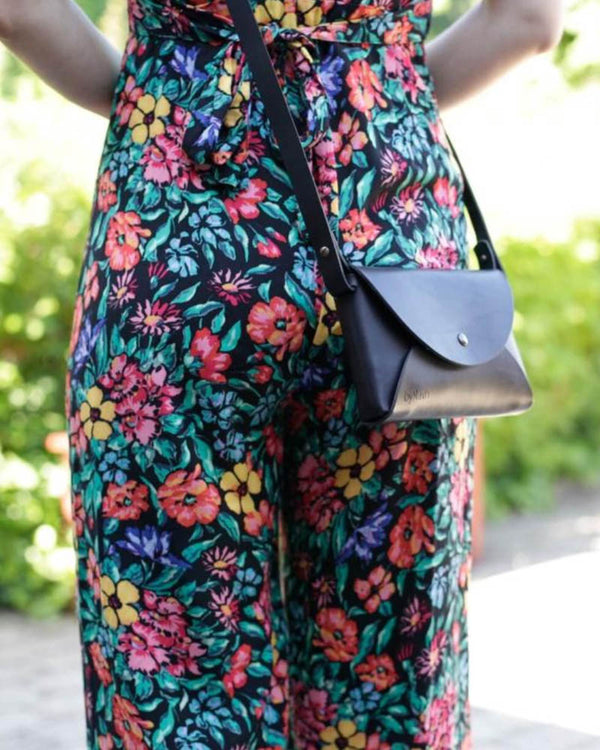 INA axelväska i svart läder buren crossbody till blommig byxdress i trädgården