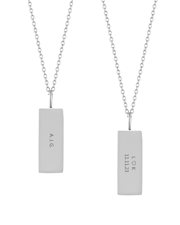 MIO halsband från byRavn i silverfärgat rostfritt stål, två rektangulära hängen med initialerna "A.J.G." och "L ♡ K 11.11.23" graverade