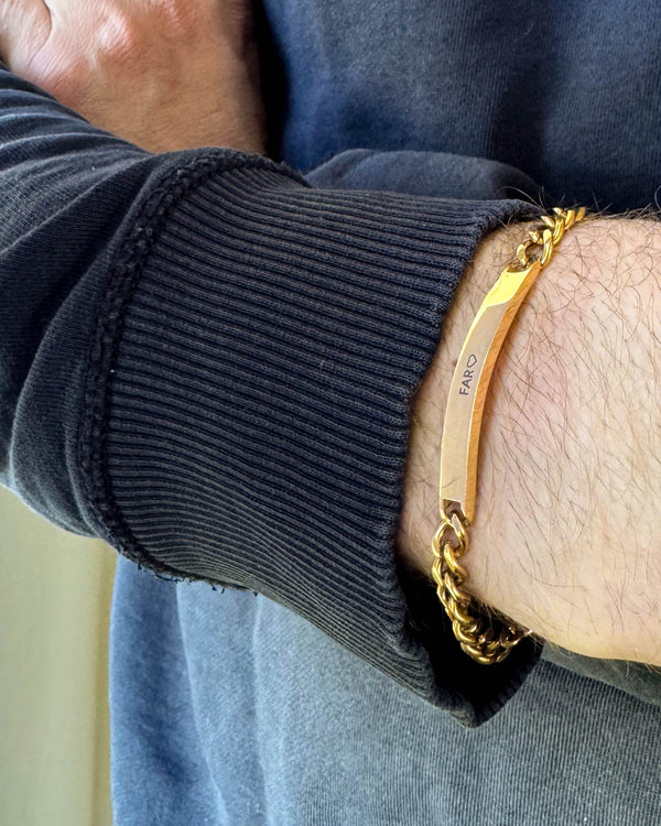 ARA armband i guldpläterat stål med gravyren "Far" ♡ runt en mans handled, svart sweatshirt