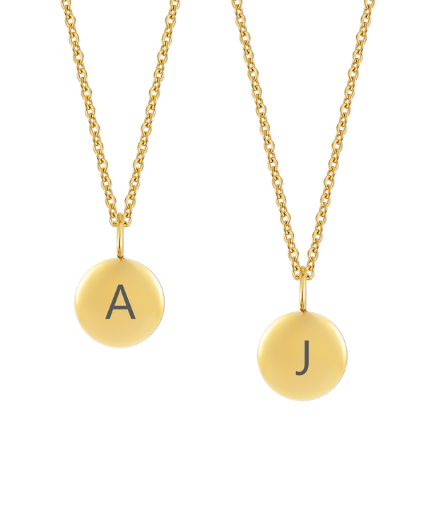 AYA LETTER halsband från byRavn i guldpläterat stål, två små runda hängen med de stora bokstäverna "A" och "J" graverade