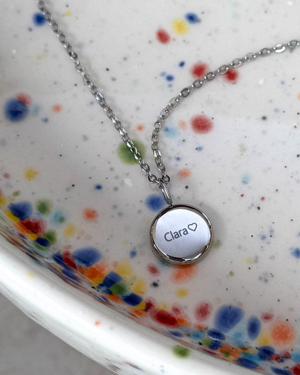 AYA NOTE namnhalsband i silverfärgat rostfritt stål med namnet "Clara" ♡ graverat på litet hänge, på prickigt keramikfat
