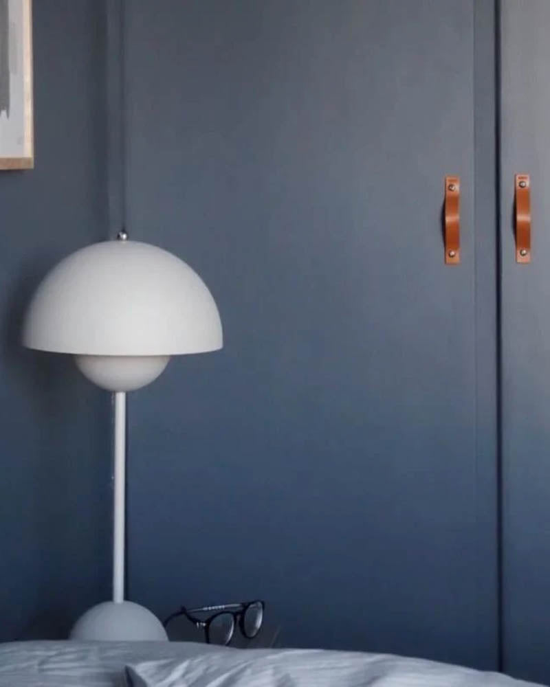 BAND handtag i cognac läder på två mörkblå skåpluckor i sovrum med vit Flowerpot-lampa
