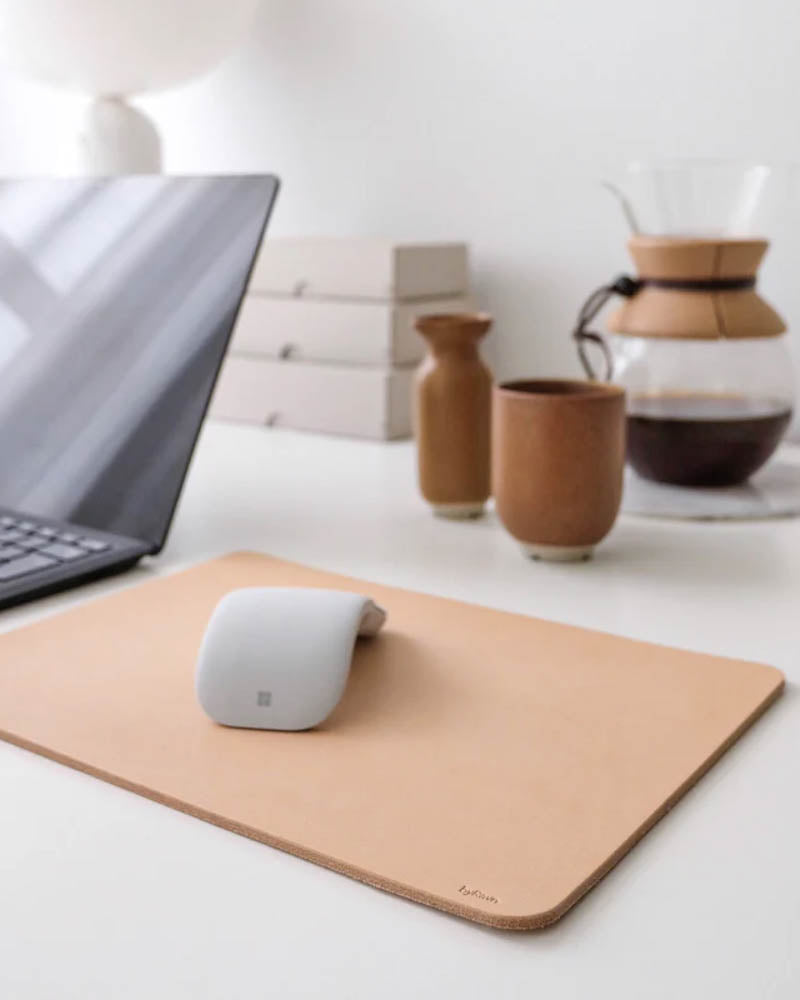 DOS musmatta i naturfärgat läder på skrivbord med laptop, mus, kaffekanna och keramikkopp