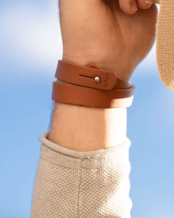 DUO läderarmband i cognac läder lindat två varv runt handleden, sett från insidan med tryckknapp och byRavn-prägling