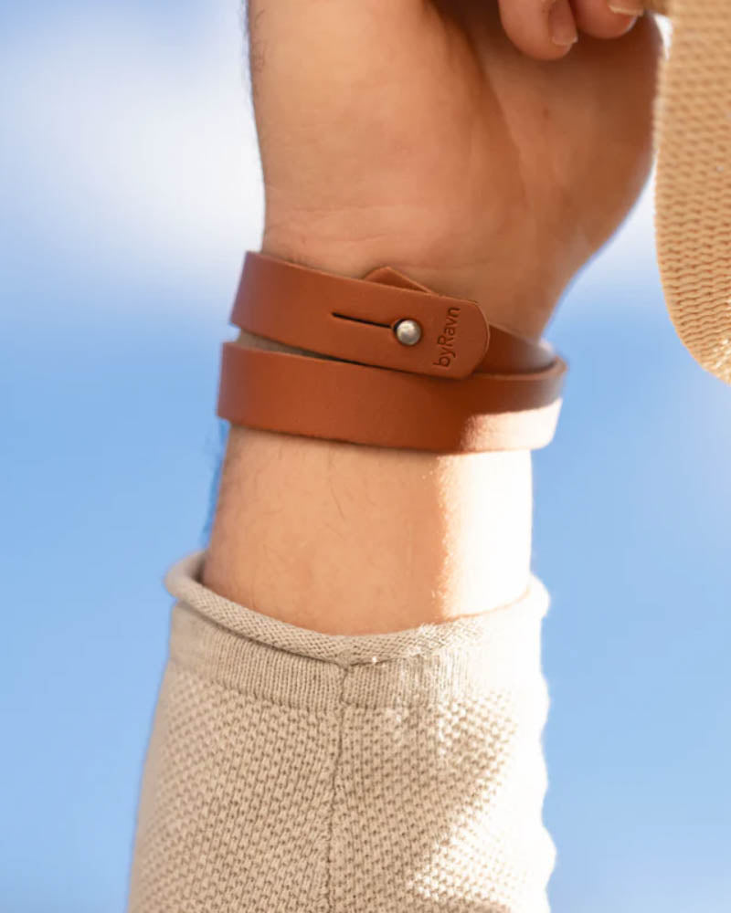 DUO läderarmband i cognac läder lindat två varv runt handleden, sett från insidan med tryckknapp och byRavn-prägling