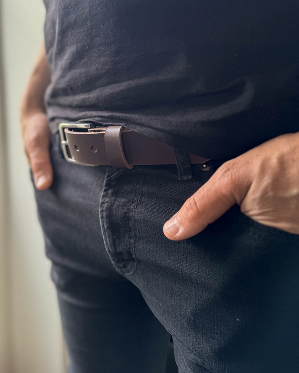 EDGE bälte i mörkbrunt läder buret i svarta jeans med svart t-shirt och handen i fickan