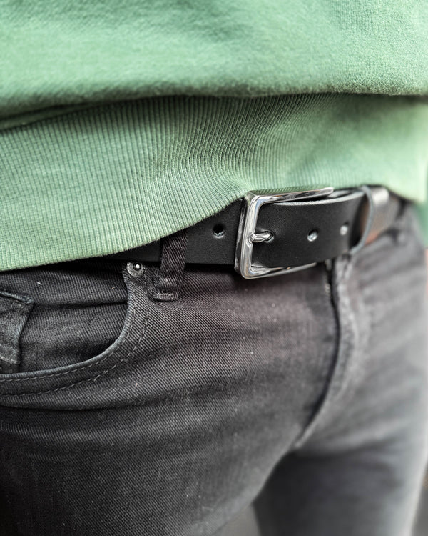 EDGE bälte i svart läder med silverfärgat stålspänne buret i svarta jeans med grön sweatshirt