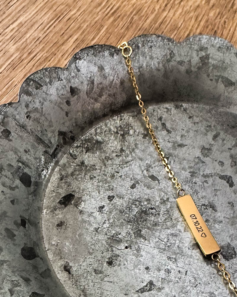 EVI armband i guldpläterat stål med datumet "07.10.22" ♡ graverat på avlång bricka, liggande på zinkfat