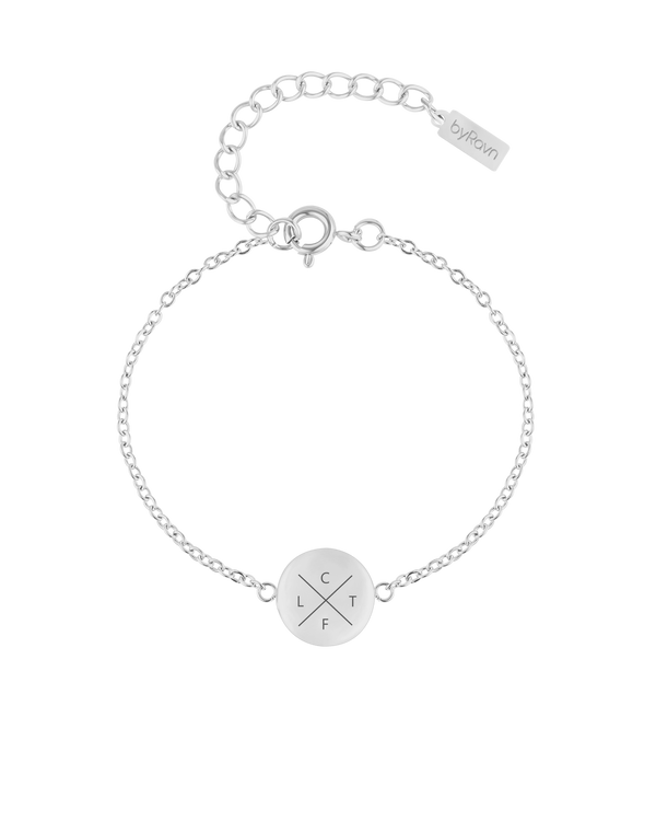 IBI X armband från byRavn i silverfärgat rostfritt stål, rund bricka med kryss och initialerna "C", "L", "T", "F" graverade