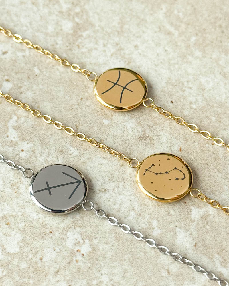 IBI STAR armband i guldpläterat stål med stjärntecknet Fiskarna och stjärnbilden Skorpionen, samt silverfärgad variant med Skytten