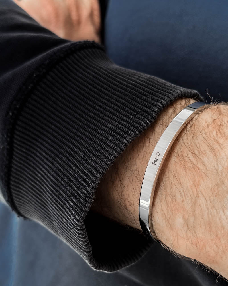 MARS armband i silverfärgat rostfritt stål med gravyren "Far" ♡ runt handleden, svart sweatshirt