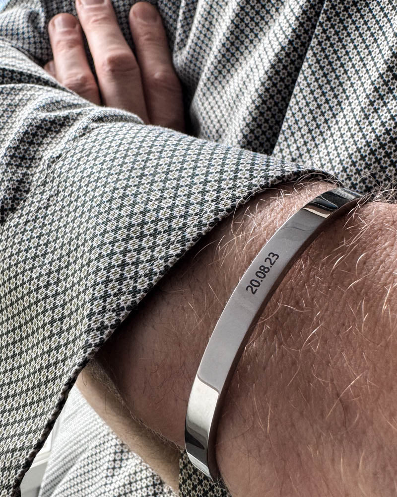 MARS armband i silverfärgat rostfritt stål med datumet "20.08.23" graverat, buret till mönstrad skjorta