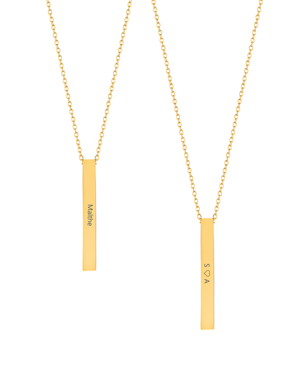 NEO halsband från byRavn i guldpläterat stål, två avlånga stavhängen med namnet "Malthe" och "S ♡ A" graverade på längden