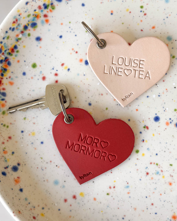 ROSE hjärtnyckelringar i naturfärgat och rött läder med gravyrerna "Louise Line ♡ Tea" och "Mor ♡ Mormor ♡" på prickig tallrik