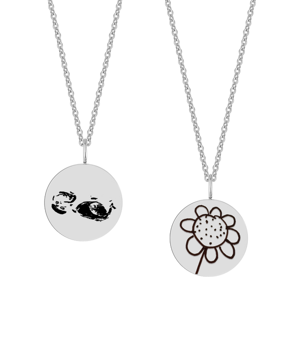 SIA MOTIF halsband från byRavn i silverfärgat rostfritt stål, två runda hängen med ultraljudsbild och barnteckning av blomma