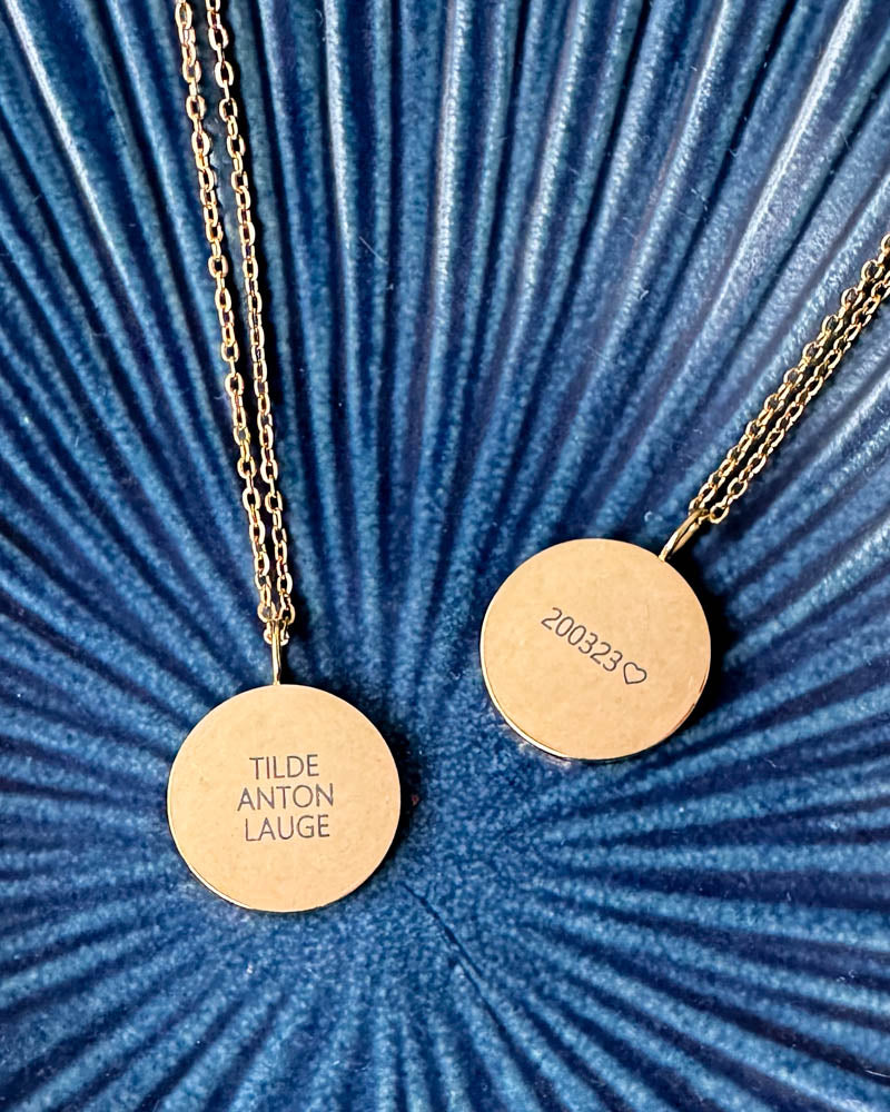 SIA QUOTE namnhalsband i guldpläterat stål, två hängen graverade "Tilde Anton Lauge" och "200323" ♡, på blå räfflad skål