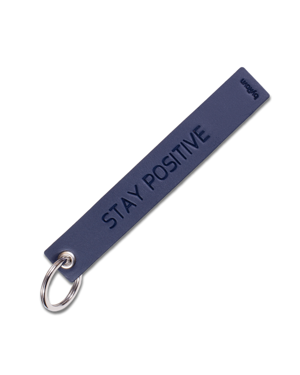 SOLO Large nyckelring från byRavn i mörkblått läder med gravyren "Stay positive" och nyckelring i stål