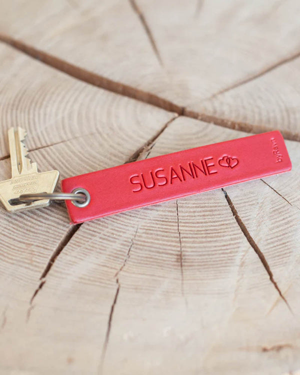 SOLO Medium nyckelring i rött läder med namnet "Susanne" och två hjärtan graverade, med nyckel på träskiva