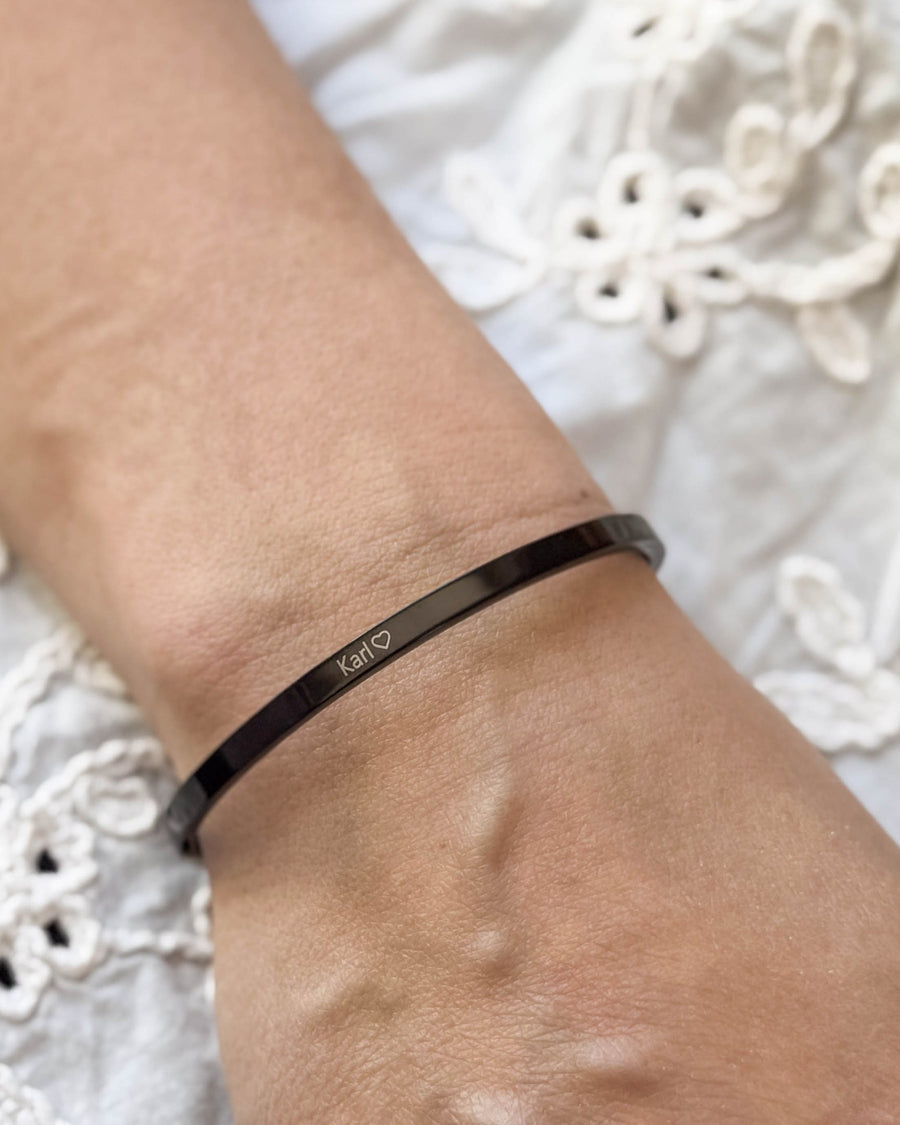 VENUS armband i svart stål med namnet "Karl" ♡ graverat runt handleden, vit broderad blus